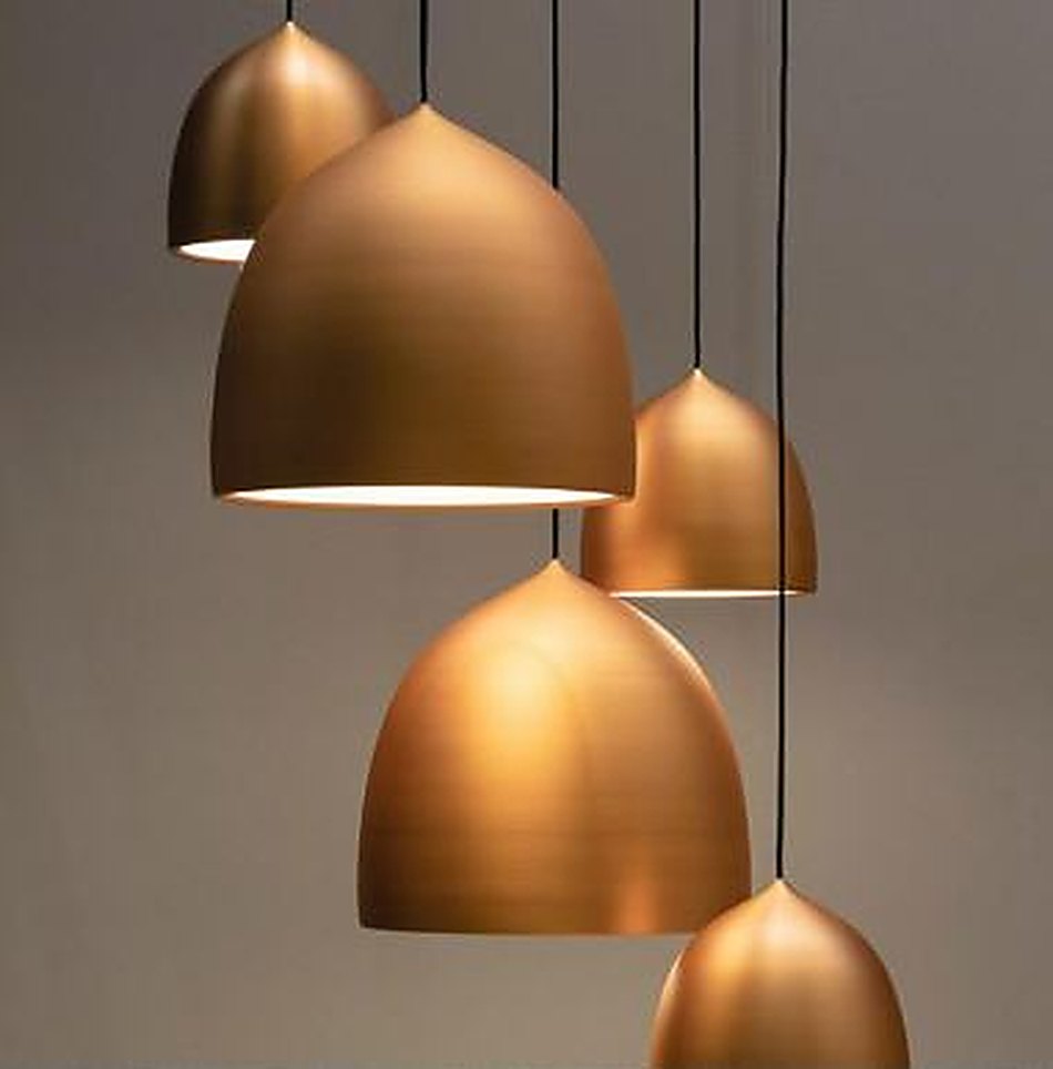 A cluster of spun brass dome pendants at staggered heights