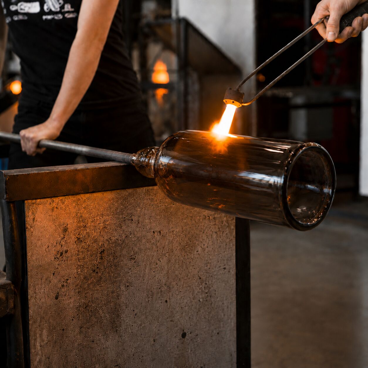 Molten glass being shaped on a blowpipe
