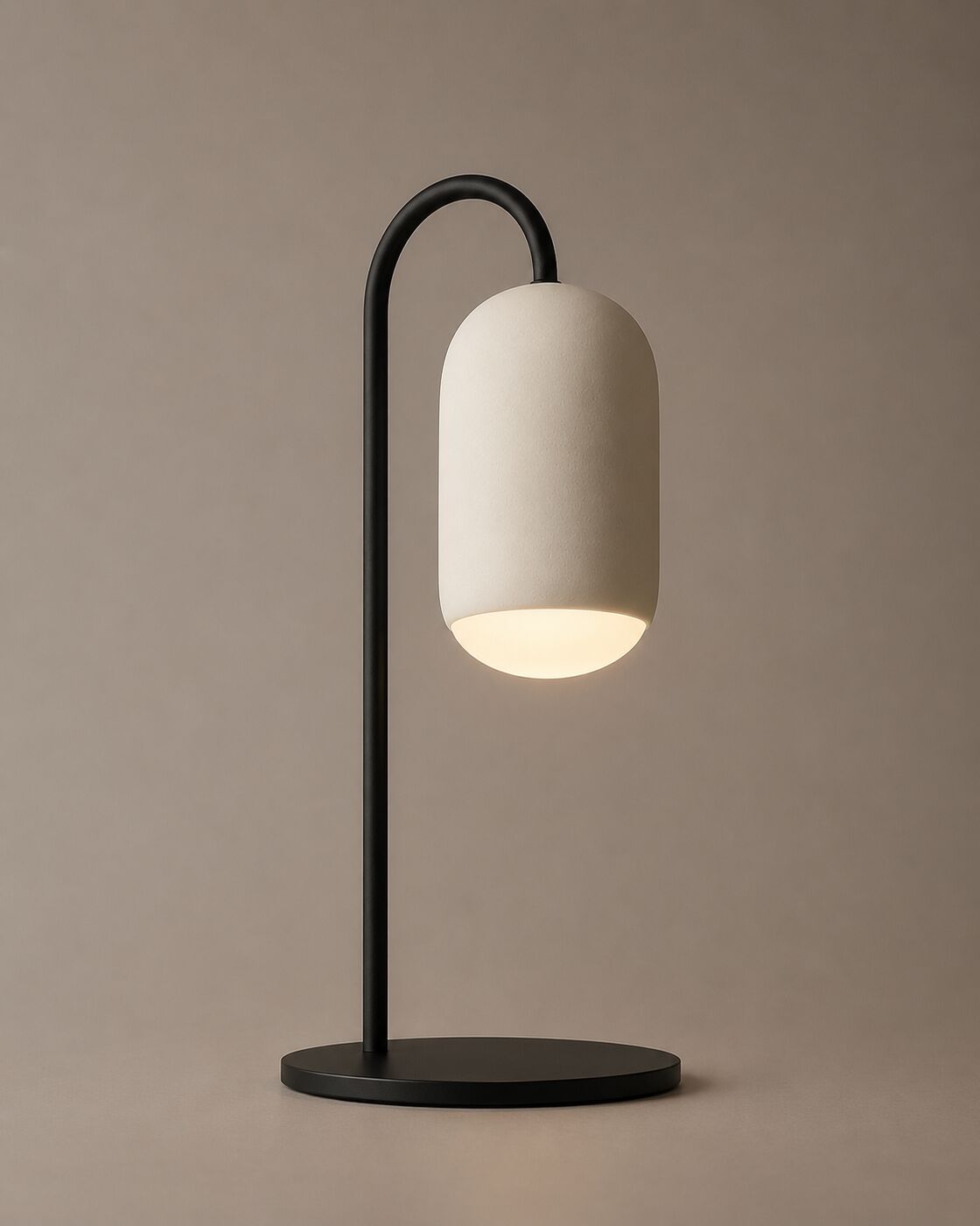 The Ova table lamp: a plaster capsule on a curved black stem