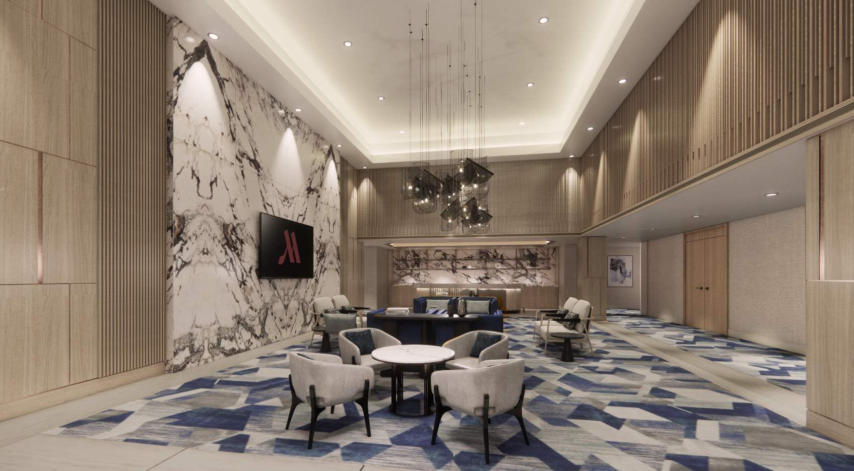 Prefunction lounge with a statement chandelier over blue patterned carpet