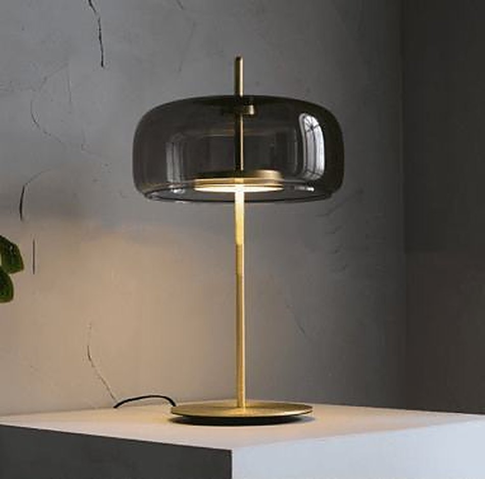 A smoked glass table lamp on a plaster ledge