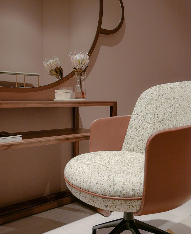 A chair and table in front of a mirror.