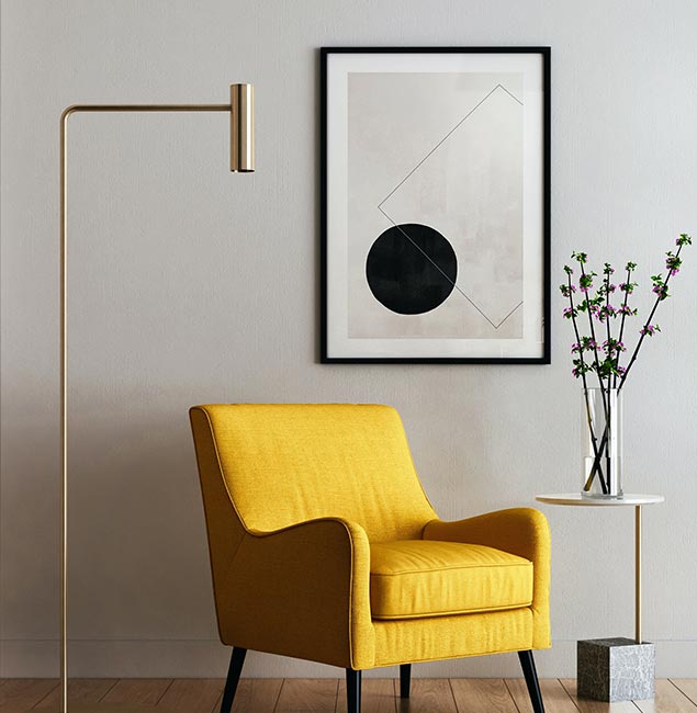 A yellow chair and a lamp in the corner of a room