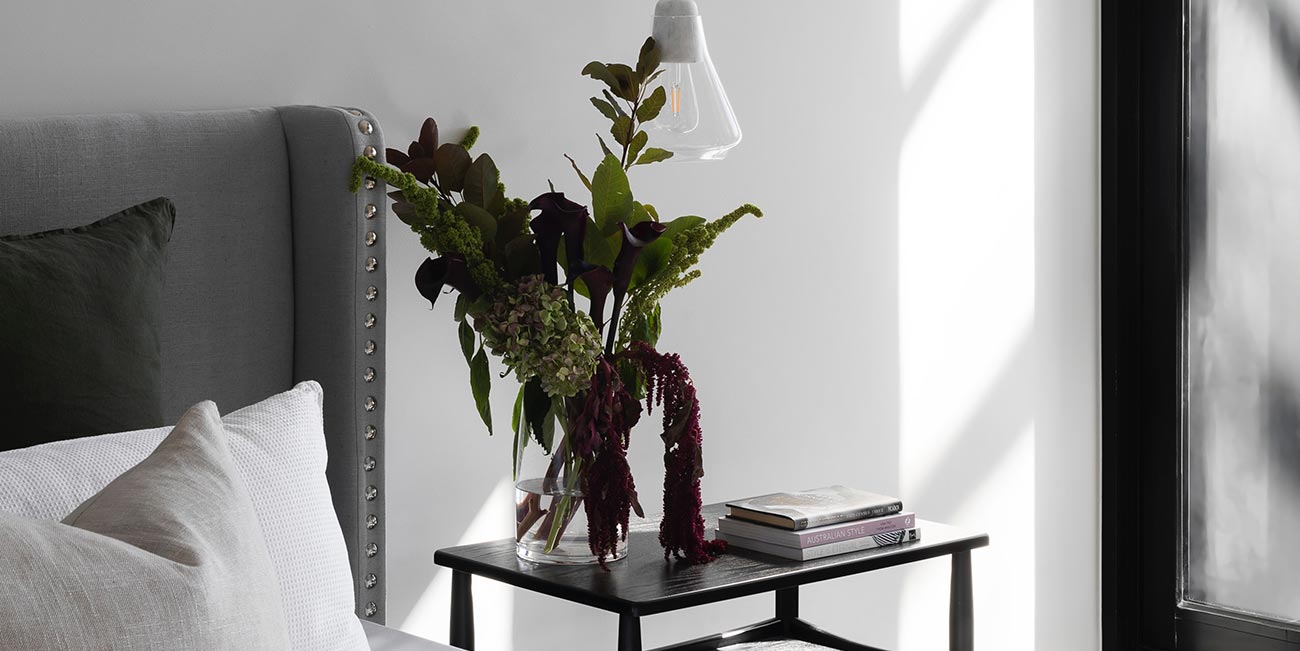 A table with two vases and flowers on it