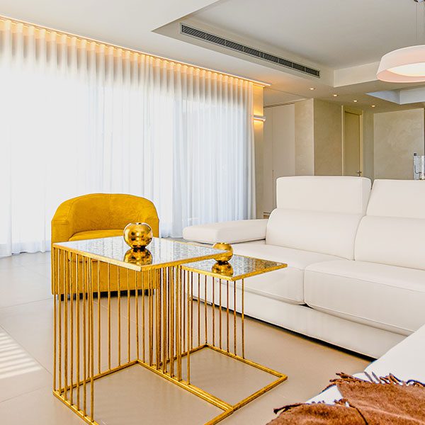 A living room with white walls and yellow furniture.